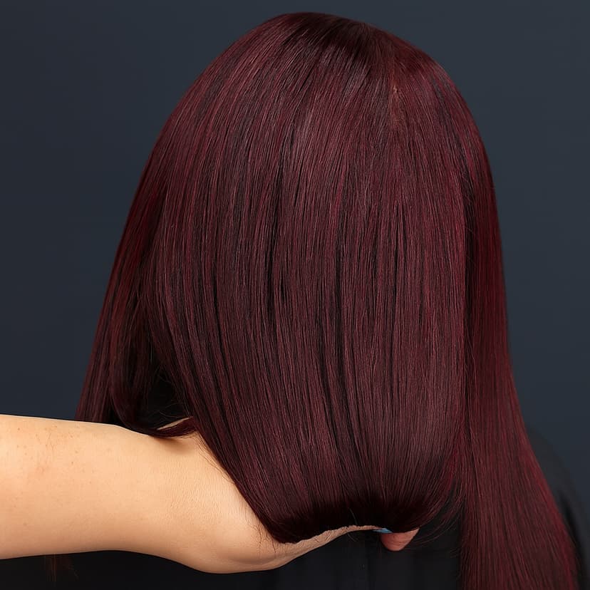Close-up of shiny burgundy hair being styled from behind